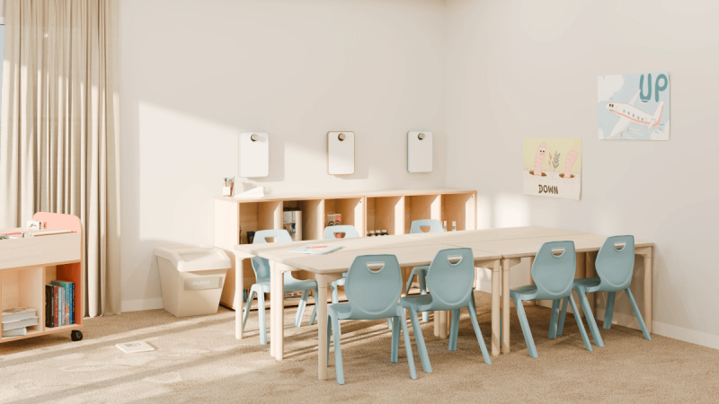 Aula infantil con mesas, sillas azules y muebles organizadores